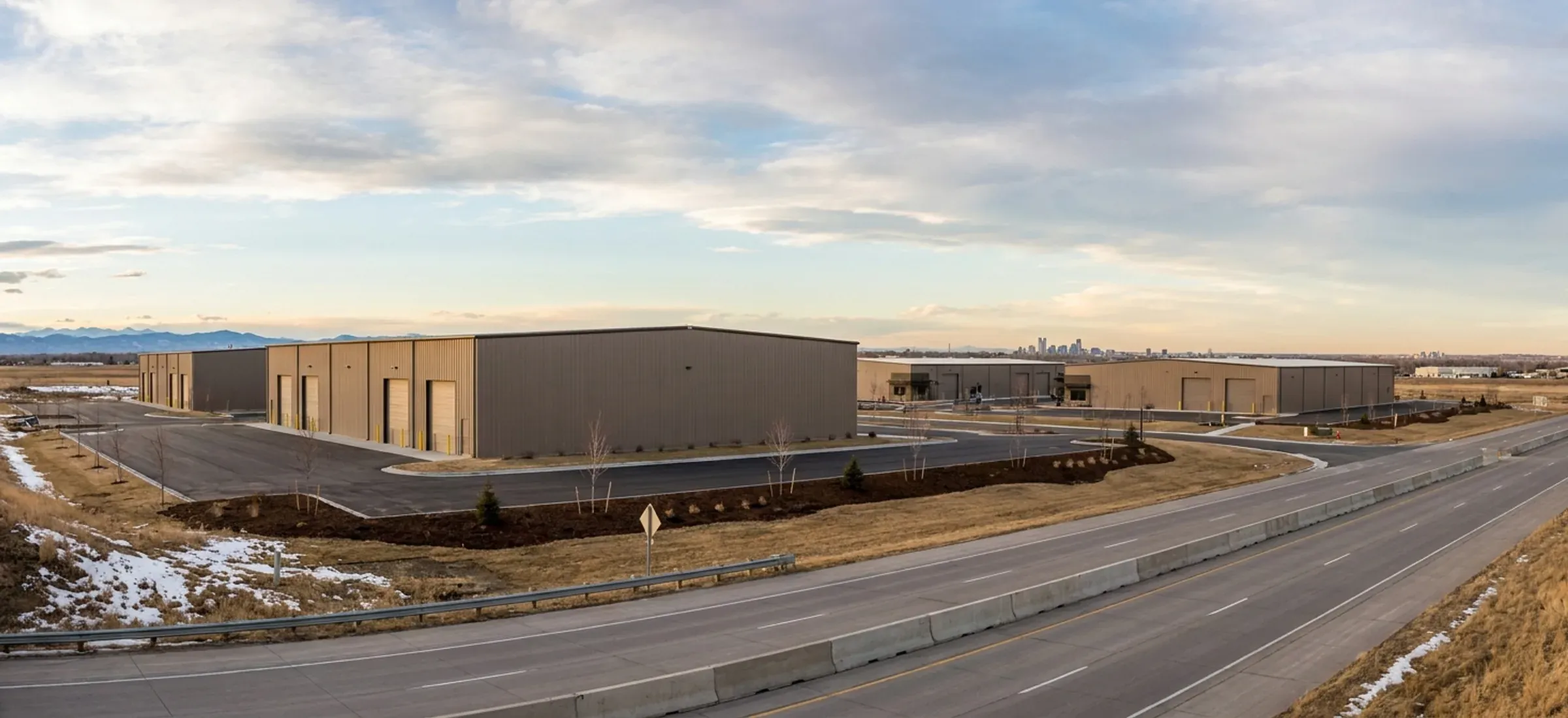 New steel commercial buildings beside a highway on flat prairie with fresh landscaping